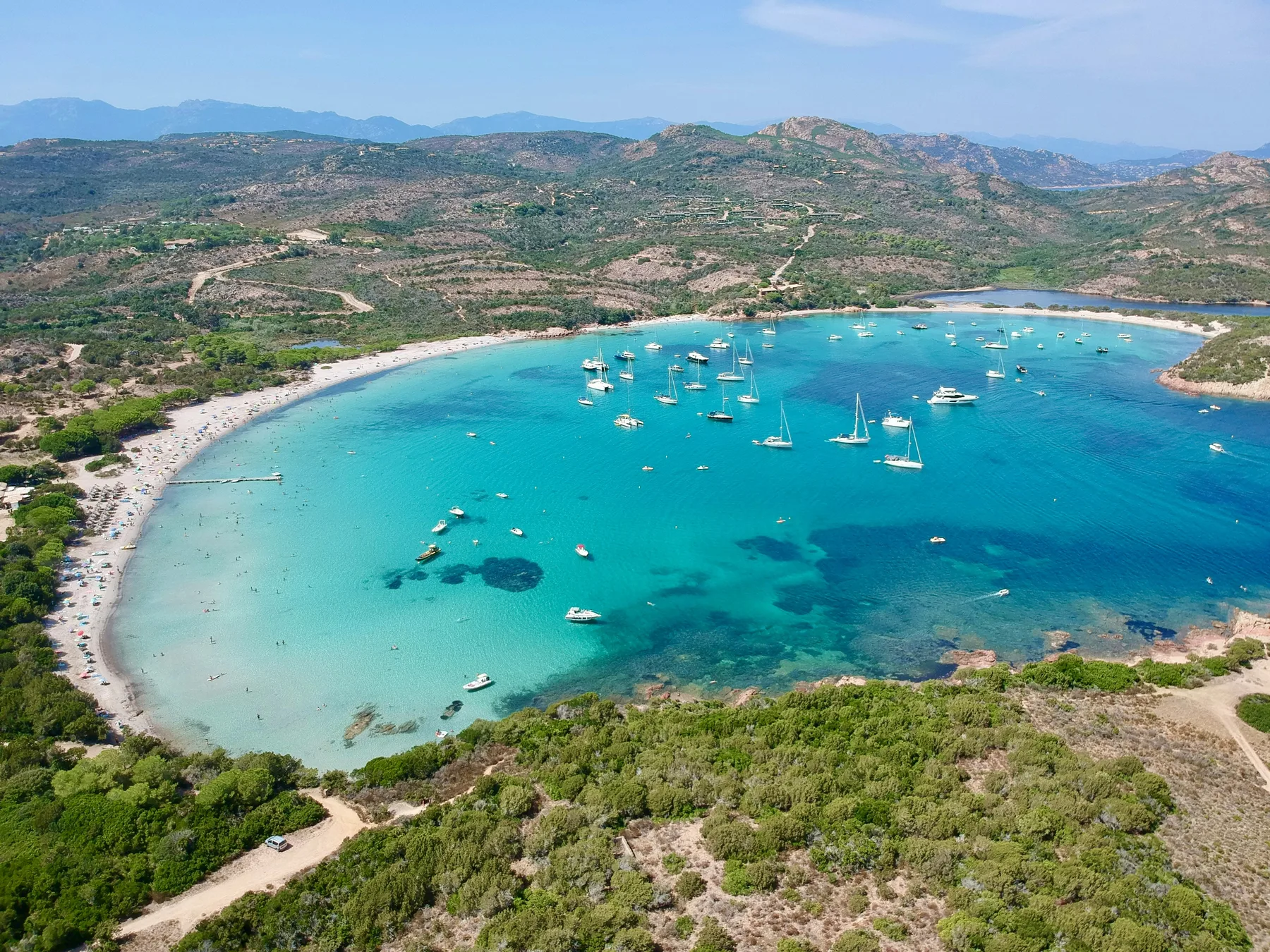 Vue aérienne de la baie de la Rondinara, ses eaux turquoise et ses voiliers, entre Porto-Vecchio et Bonifacio